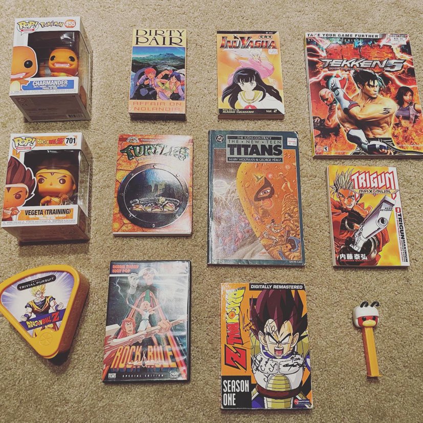 An assortment of vibrant orange items from a collection of 80s, 90s, and 2000s anime, comic books, cartoons, video games, and collectibles.